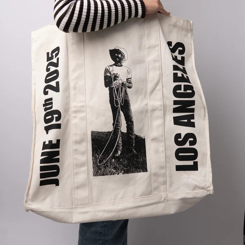 Cream Post Malone merch tote bag side view showing cowboy rope graphic and Los Angeles text design fan apparel streetwear